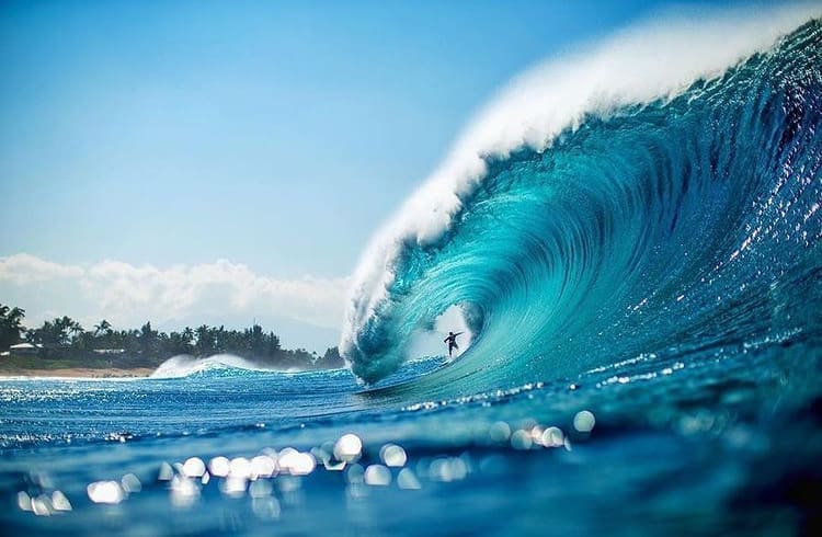 Surfing through a barrel at Banzai Pipeline