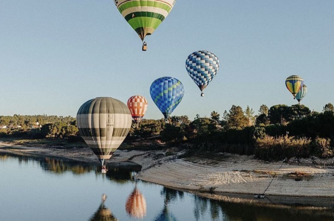 Hot air balloons taking flight over the Alentejo fields, one of the best activities in portugal for honeymoon