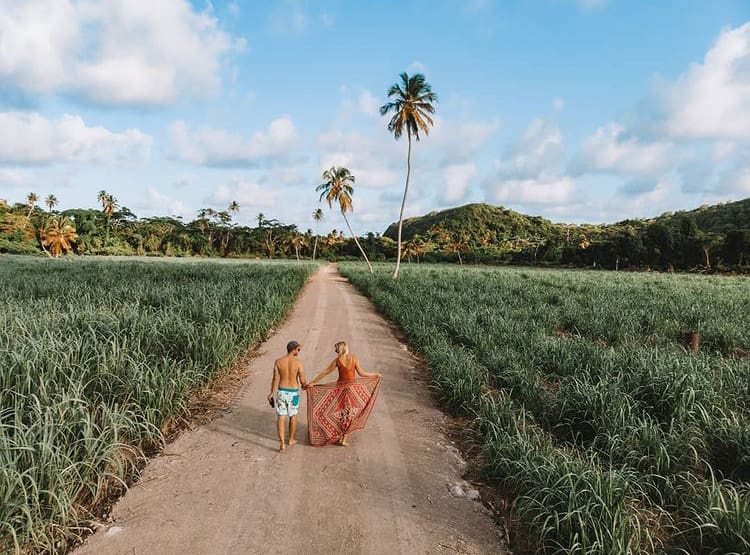 Couple walk along a road in rural Grenada 