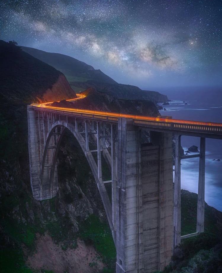 Night time view as cars drive over the Bixby Creek Bridge - The 10 Best Road Trips On The West Coast
