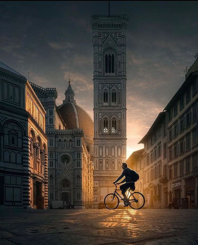 The sun sets over Florence as a cyclist rides home 