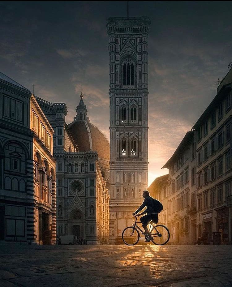 The sun sets over Florence as a cyclist rides home