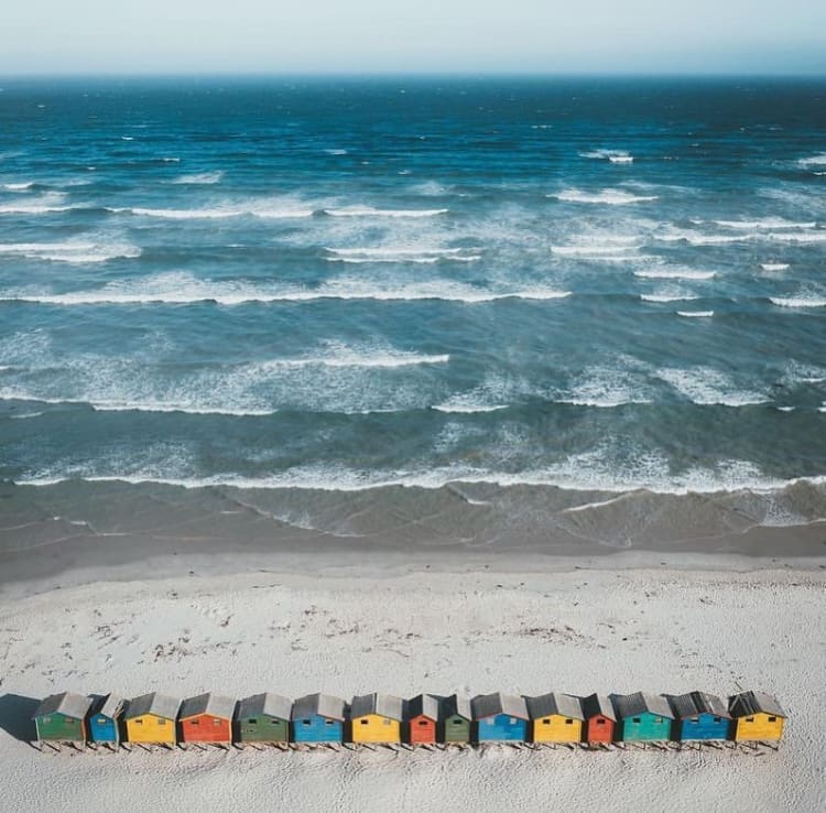 Colourful beach huts and ocean swell at Muizenberg Beach - The 10 Best Places to Surf in South Africa