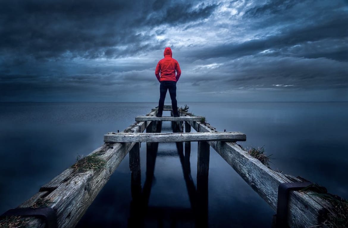 Man in red jacket looking out over Lough Neagh
