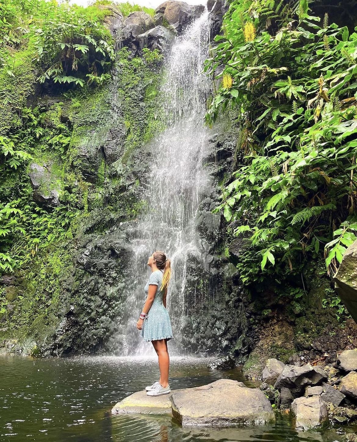 Woman admiring a waterfall on Sao Jorge Island, Portugal