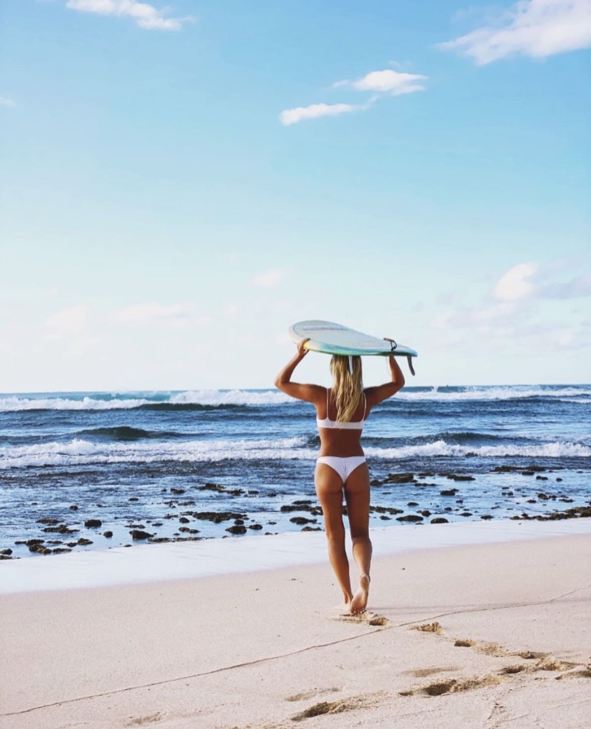 Setting out to surf at sunset beach